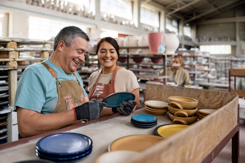 Two employees inspecting pottery.