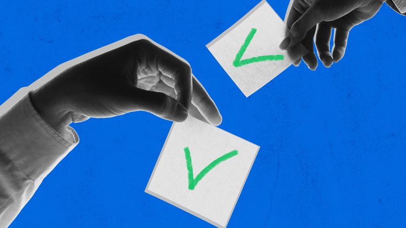 Two hands in black and white, holding pieces of paper with check marks on them.