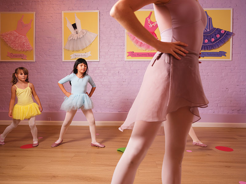 Three young dancers following the lead of a dance instructor in front of them