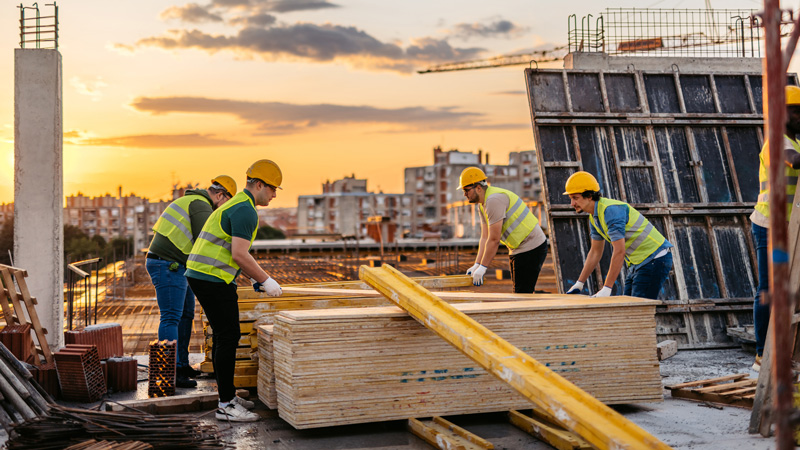 Four construction workers working with wood