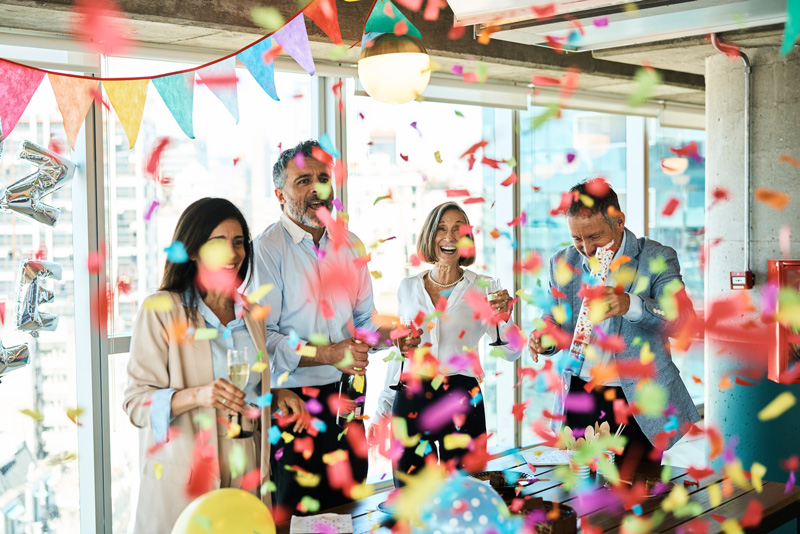 Four people in an office, throwing confetti and celebrating